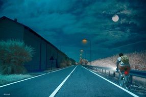 cyclist on the road to the full moon