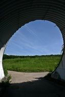 underpass in front of a green meadow