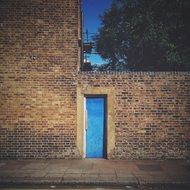 blue door in red brick wall on street