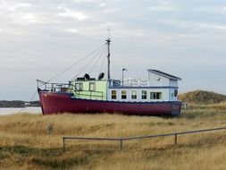 ship on dry grass ashore