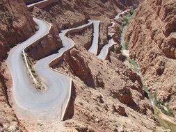 free curved road on mountain side in wilderness