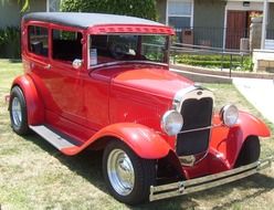 red antique car on green grass