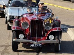 driver and passenger in retro cabriolet