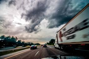 truck on the road under dark clouds