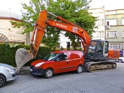 excavator and cars in the parking lot