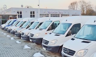 row of white minivan cars for sale