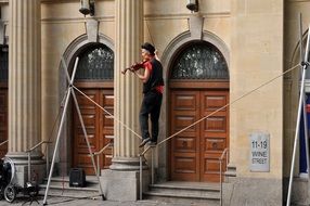 tightrope walker with violin as a street artist