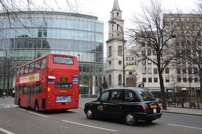 cityscape of Red bus and black car in England