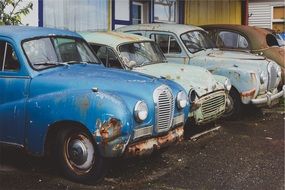 old rusty cars in row