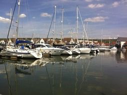 boats are reflected in the water in a quiet harbor