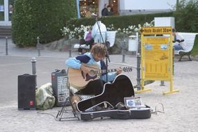 street musician with a guitar on a walking street