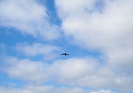 distant plane flying at clouds