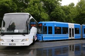 accident of a white bus and blue tram