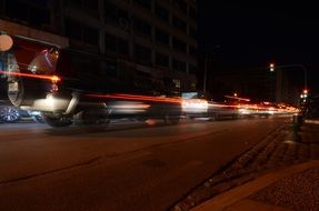 cars drive at speed on the road at night