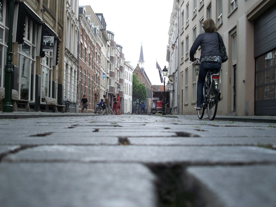 cyclist riding on pavement of old street in town