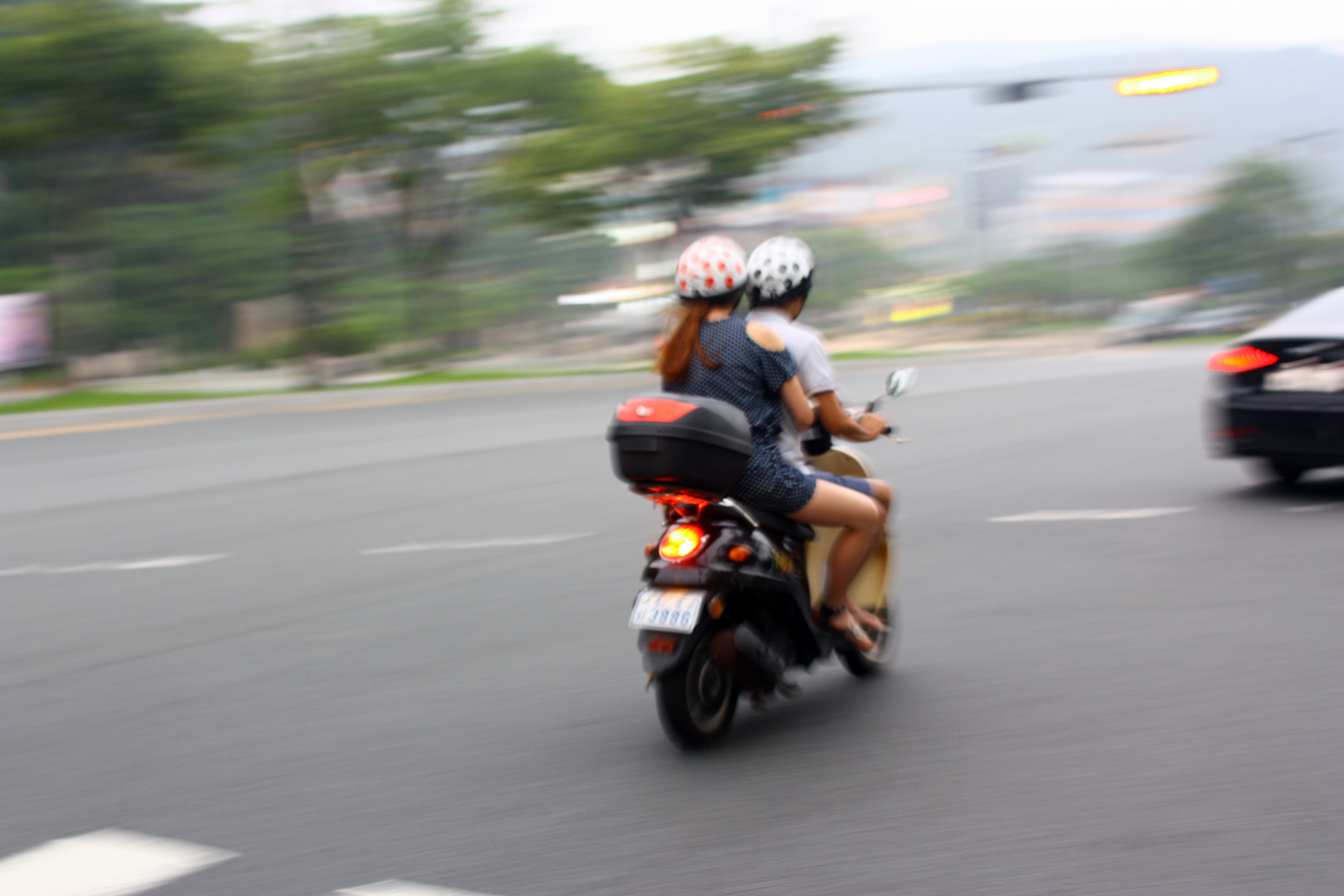 Couple on a motorcycle in city traffic in a blurry background free image