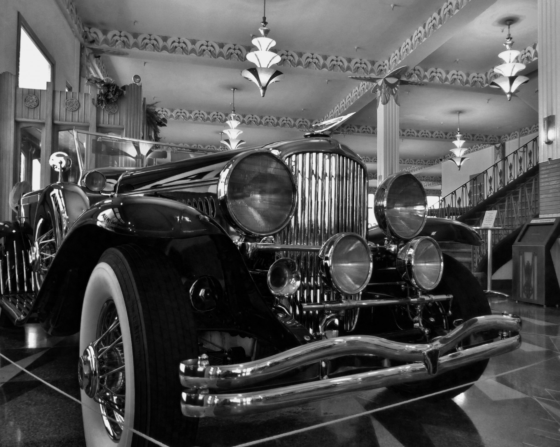 Black and white photo of an antique car in a museum free image download
