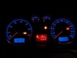 blue and red illuminated dashboard of passat car in darkness