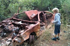 boy at the broken rusty car