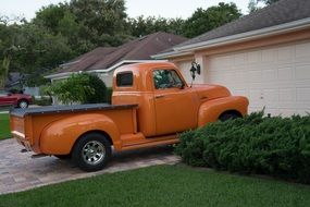 Chevrolet orange pickup is parked at home