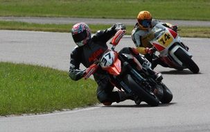 two motorcycle riders on a race track