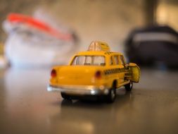 ceramic taxi figurine stands on a table at blurred background