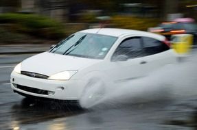 white car in aquaplaning on the road