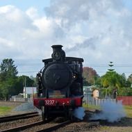 steam train on tracks on a cloudy day