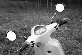 black and white photo of a scooter on the grass