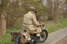 soldier in historical clothes on an old motorcycle