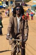 man with dreadlocks riding bike