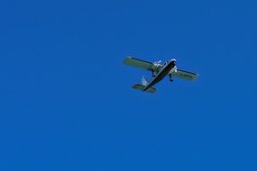 light aircraft in flight in bright blue sky