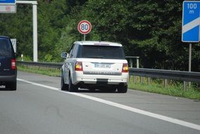 white car in front of the speed limit sign