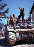 the soldiers are sitting on the tank