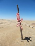 stop sign at railway in desert