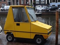 yellow tiny car on street in city