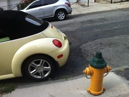 black beige volkswagen beetle parked by a fire hydrant