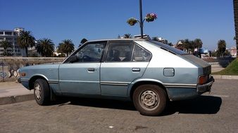 old grey car parked in city