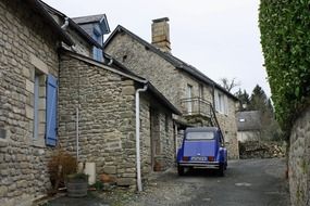 parked blue car on a stone street