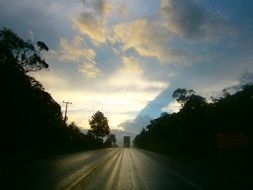 landscape of clouds and road and trees