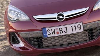 front part of burgundy car with a license plate