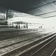 black and white photo of train tracks at a train station