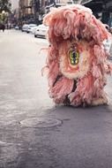 fantasy costume with pink feathers on street