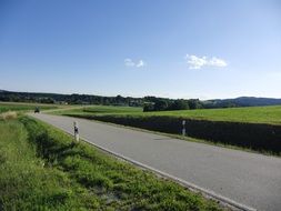asphalt road beneath blue sky at countryside