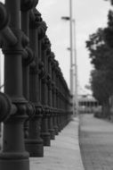 cast iron fence on street, black and white