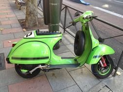 light green scooter is parked on the street
