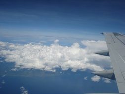 airplane wing over white clouds