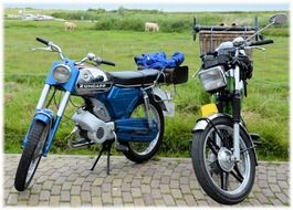 motorcycles stand on the road near a green meadow