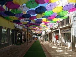 umbrellas of different colors over the pedestrian street