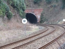 rails on the railway lead into the tunnel